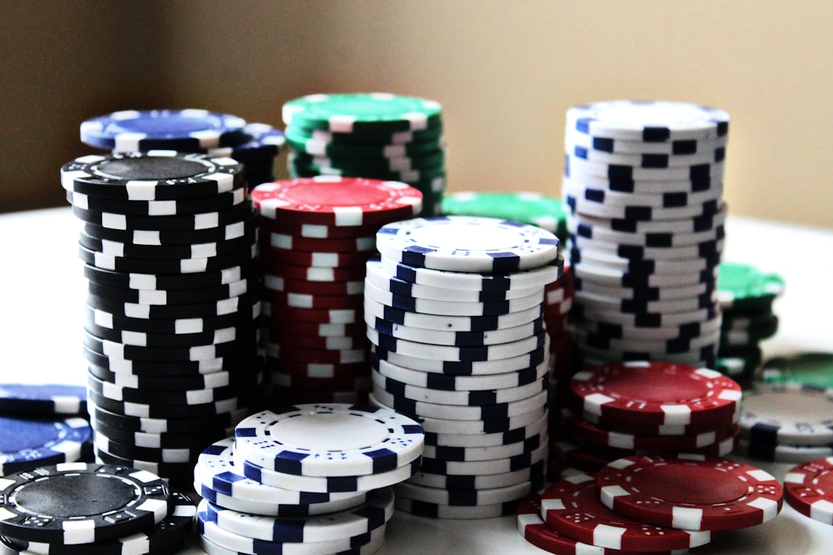 Tumpukan chip poker berbagai warna di meja permainan